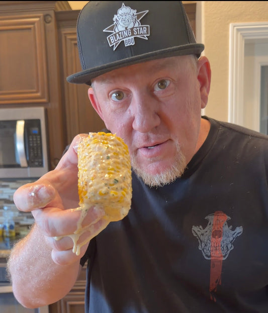 Mike Starr holding Scorpion Cream Corn on the Cob coated in creamy Parmesan sauce and Blazing Star Scorpion Rub.