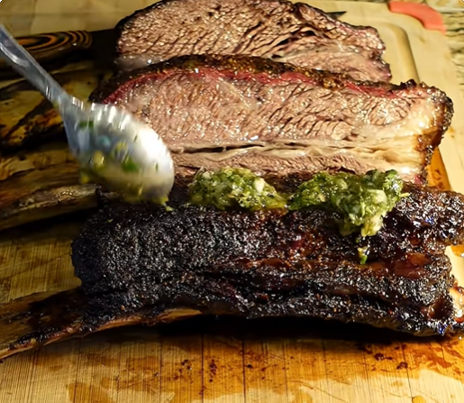 Smoked beef dino ribs topped with shishito pepper chimichurri