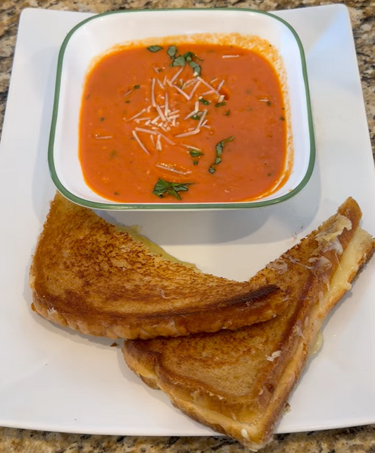 Homemade tomato soup with smoked cheddar and Gruyère grilled cheese sandwich