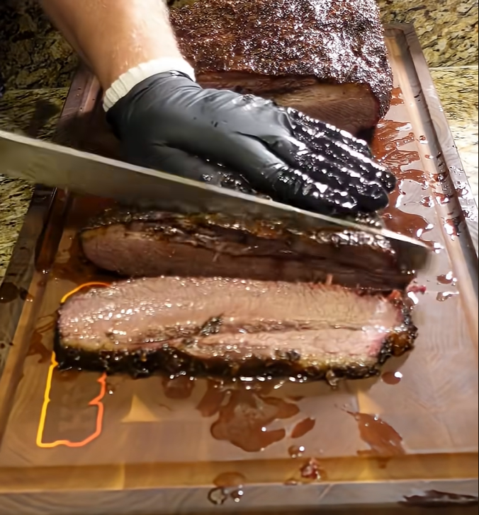 Slicing smoked brisket seasoned with Blazing Star BBQ rub